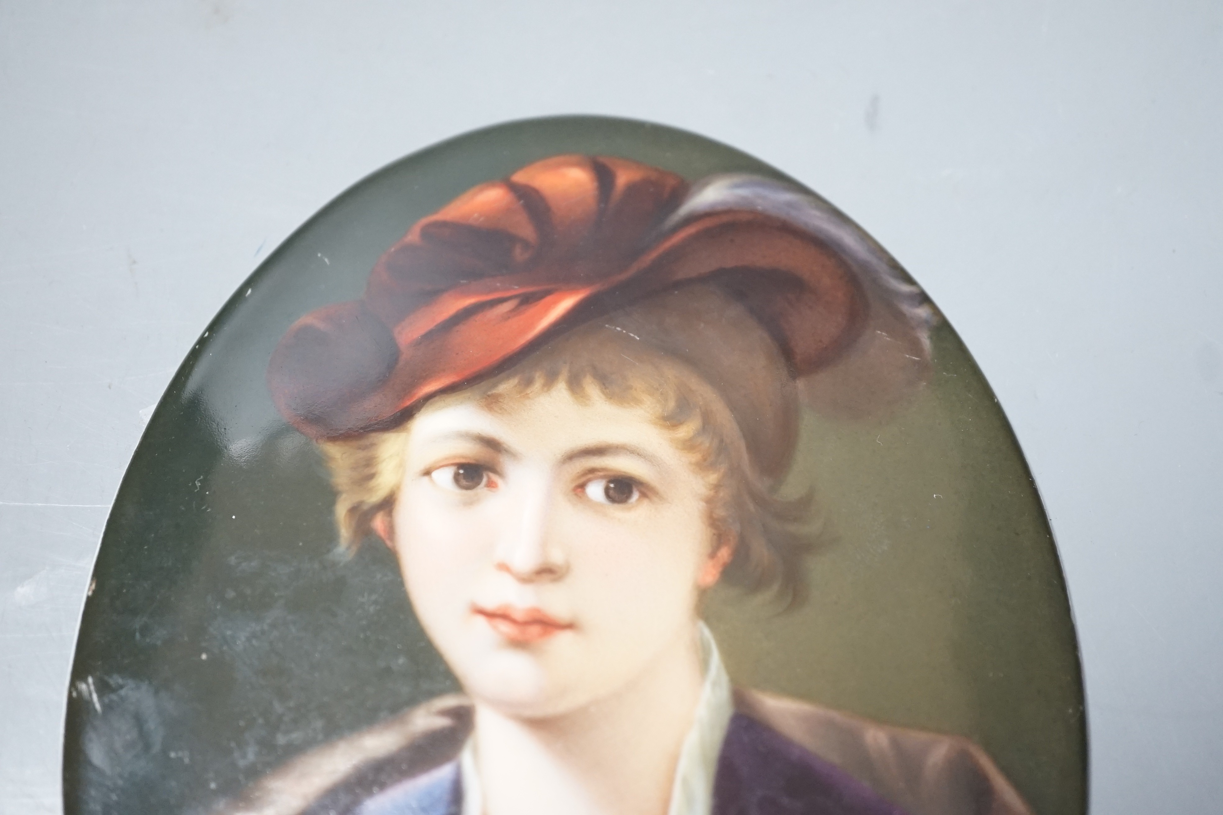 A 19th century oval painted porcelain plaque of a girl, 17 x 13cm